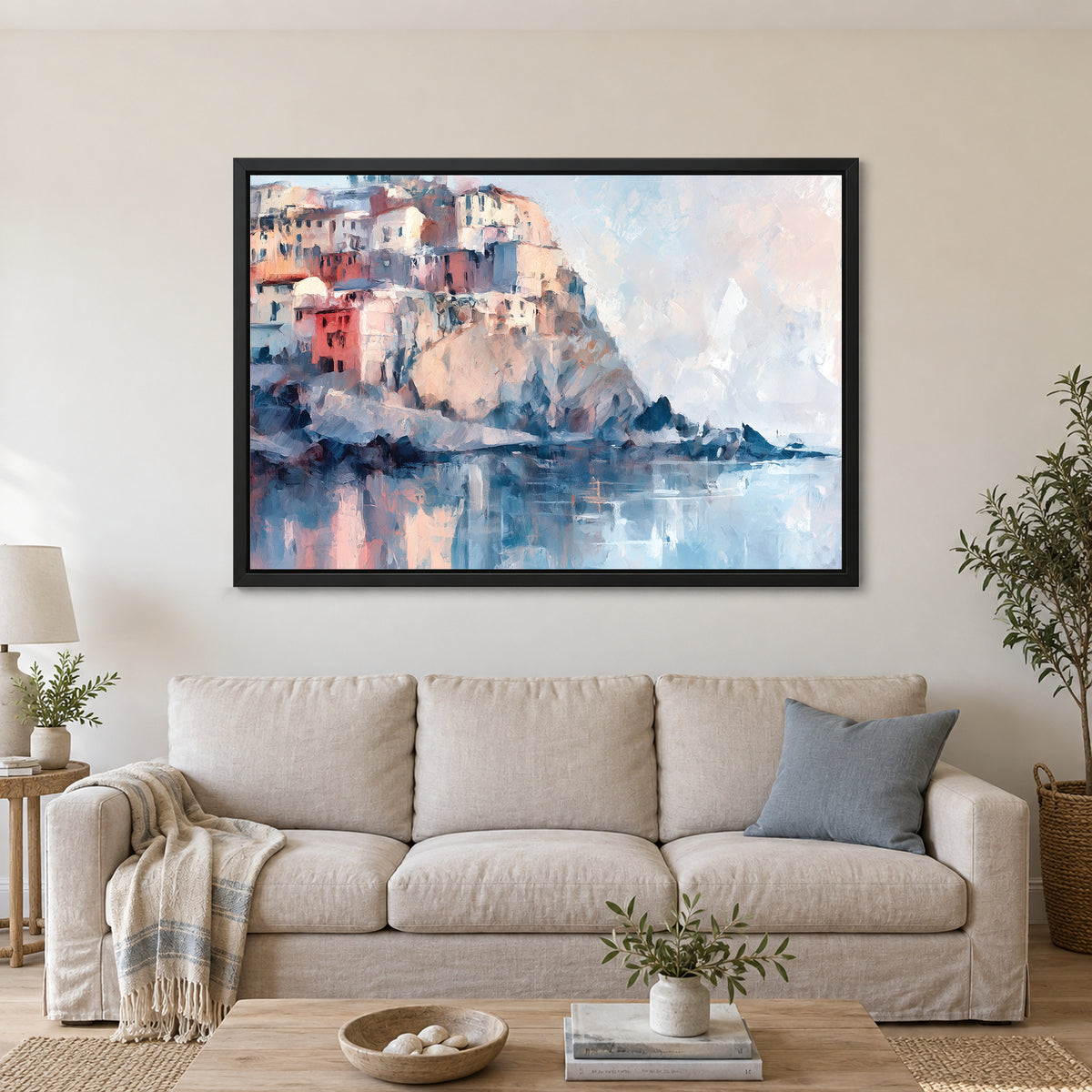 Cinque Terre Cliff Houses Coastal framed canvas in a black floating frame above a linen sofa with a blue cushion