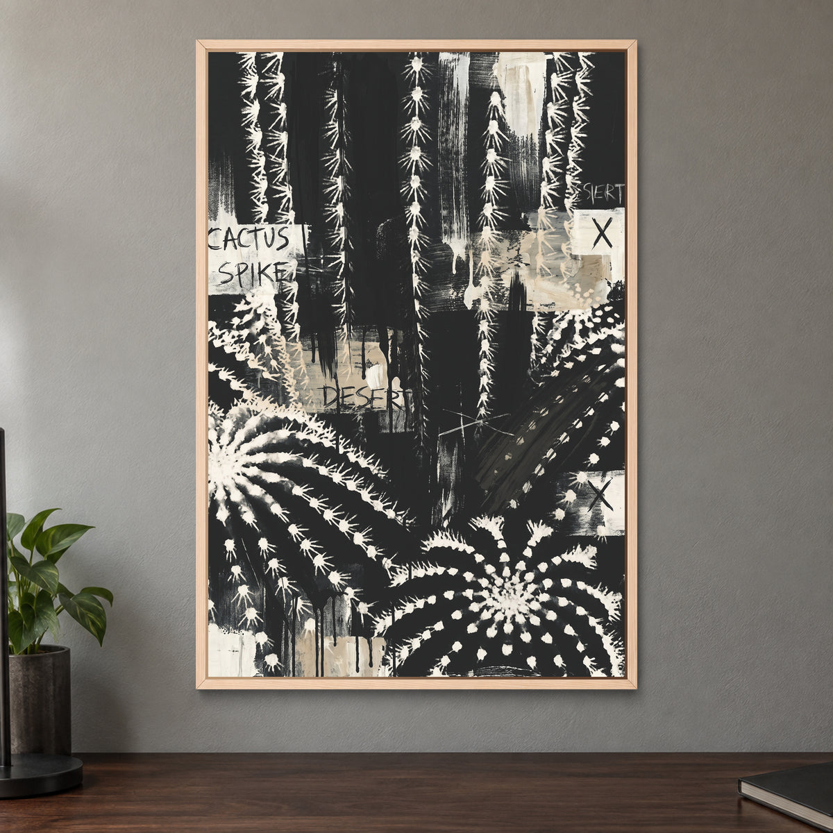 Black and White Cactus Desert framed canvas in a natural wood floating frame on a taupe wall above a dark walnut sideboard with a potted plant