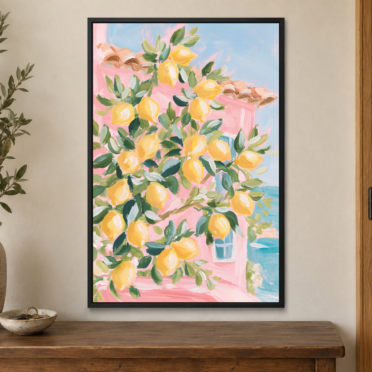 Lemon Tree and Blue Shutters framed canvas in a black floating frame on a cream wall above a wooden sideboard beside a door frame
