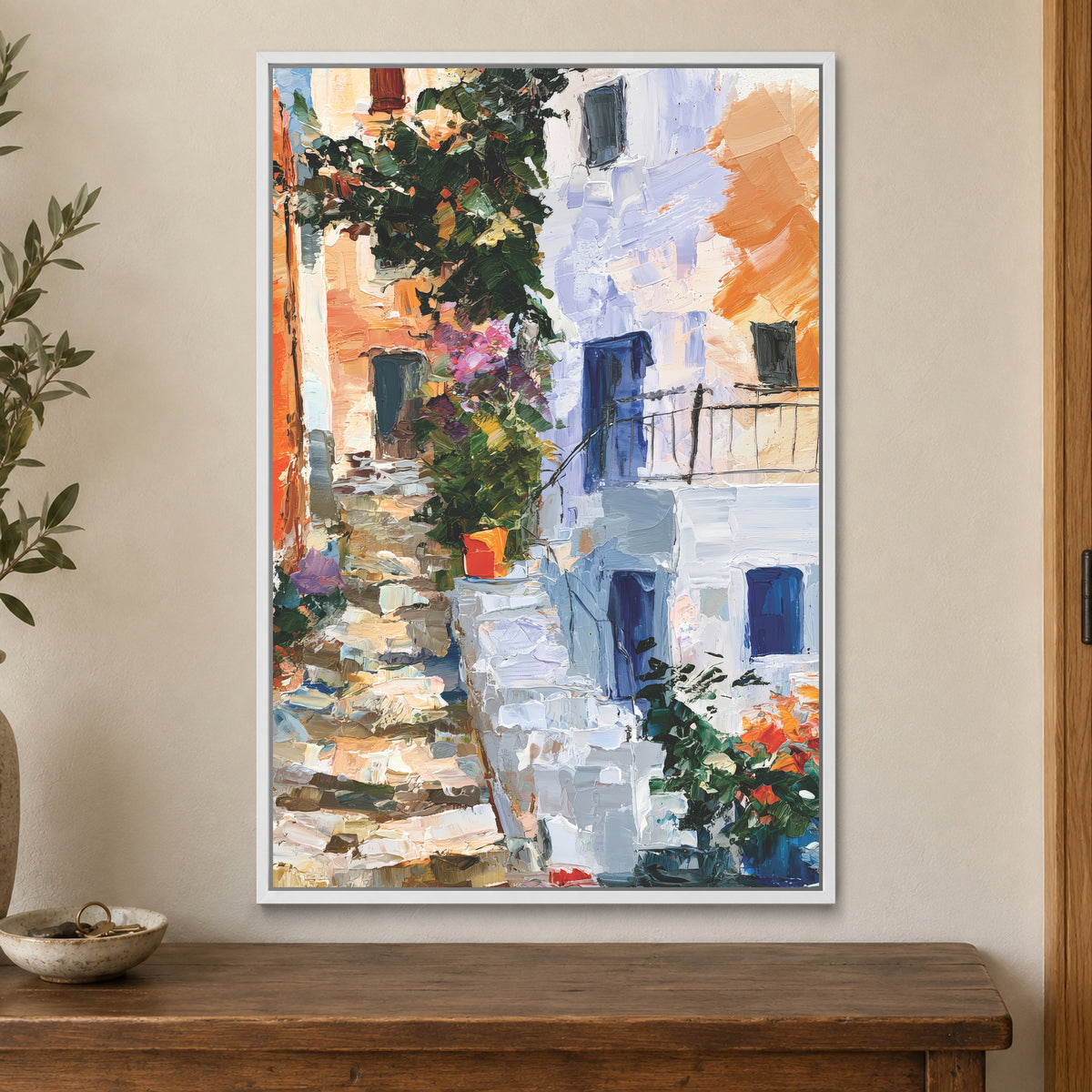Whitewashed Alley Stone Steps framed canvas in a white floating frame on a cream wall above a wooden sideboard beside a door frame