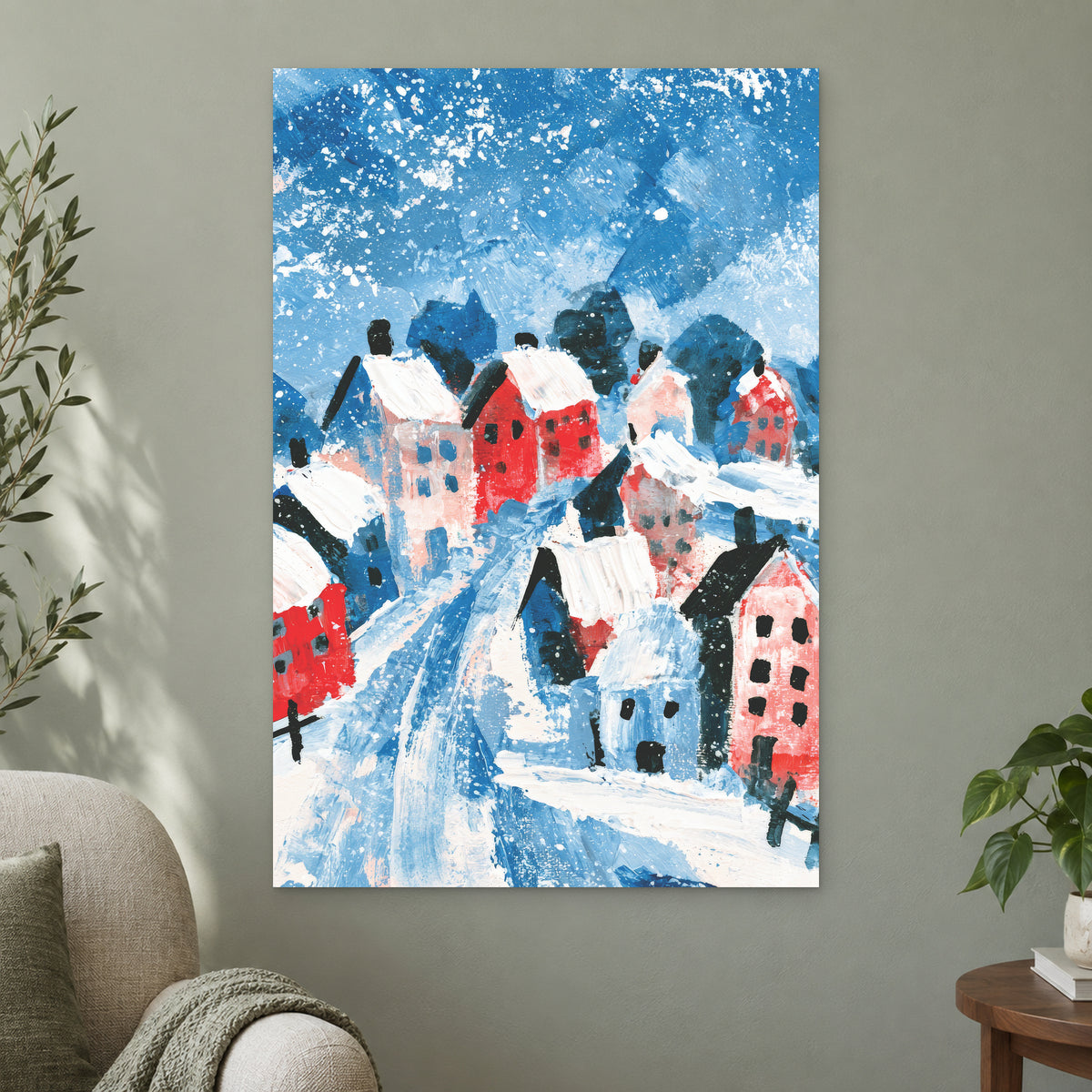 Winter Lane Between the Houses canvas wall art on a sage green wall beside a cream armchair