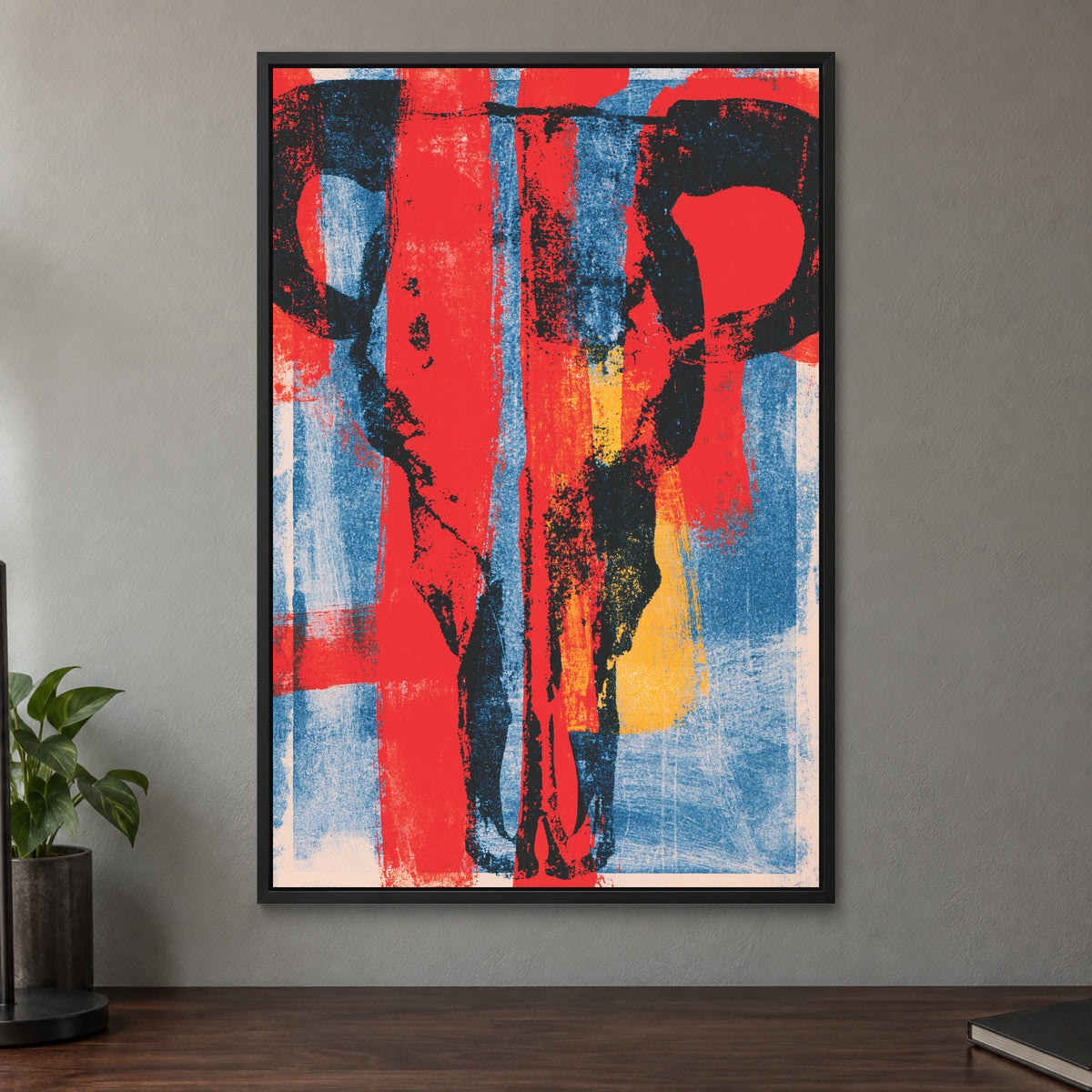Bull Skull Bold Screenprint framed canvas in a black floating frame on a taupe wall above a dark walnut sideboard with a potted plant
