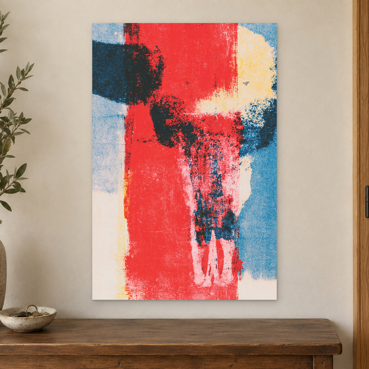 Red Field Skull Abstract canvas wall art on a cream wall above a wooden sideboard beside a door frame
