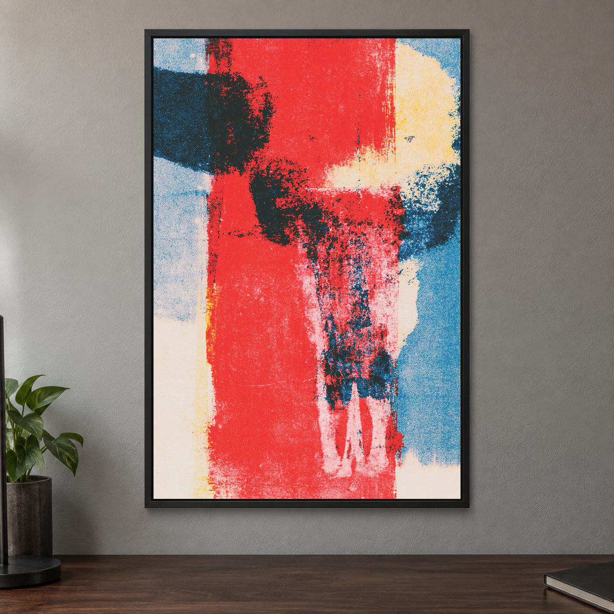 Red Field Skull Abstract framed canvas in a black floating frame on a taupe wall above a dark walnut sideboard with a potted plant