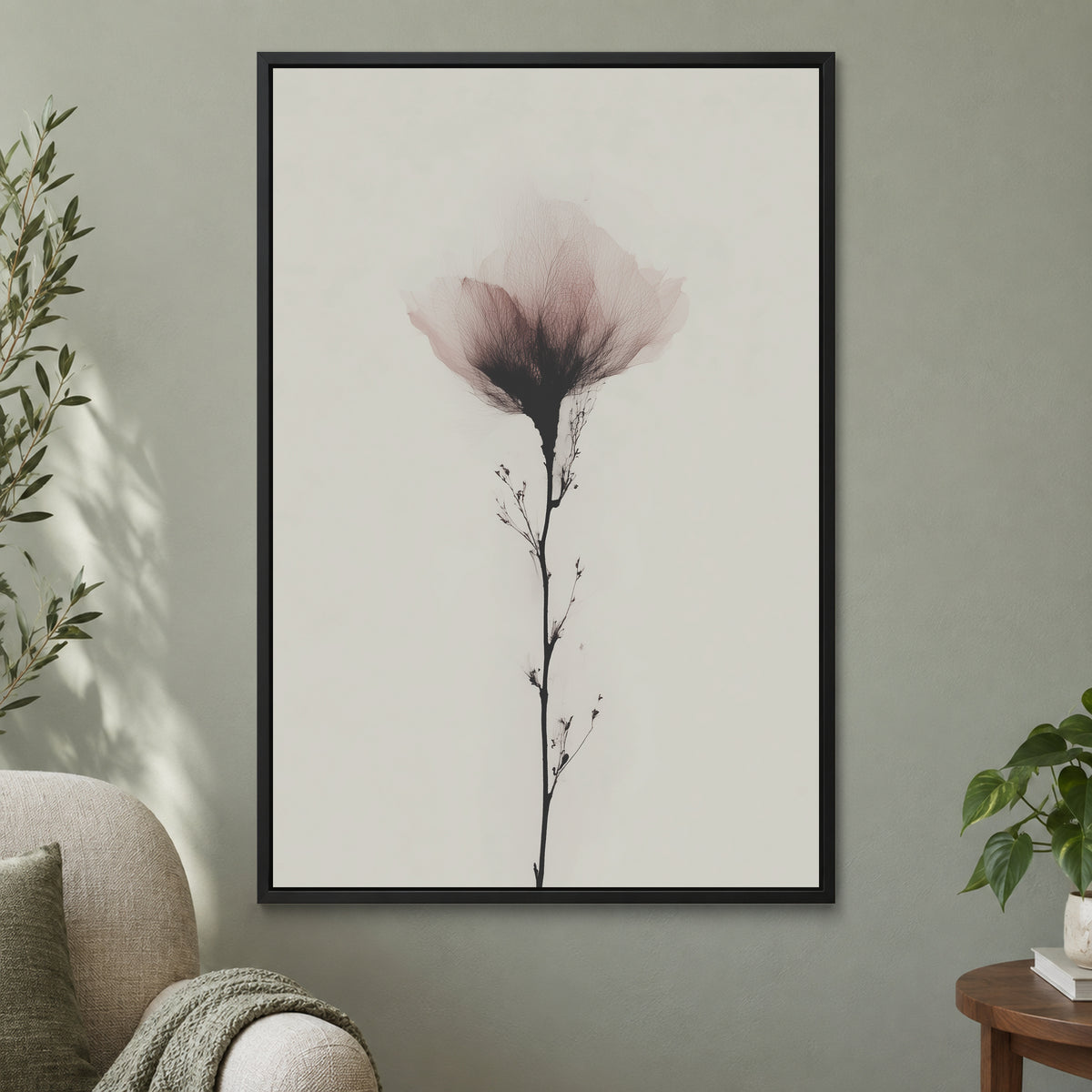 Single Stem Pink Bloom framed canvas in a black floating frame on a sage green wall beside a cream armchair