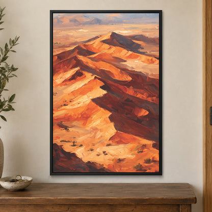 Desert Dunes Aerial Ridge framed canvas in a black floating frame on a cream wall above a wooden sideboard beside a door frame