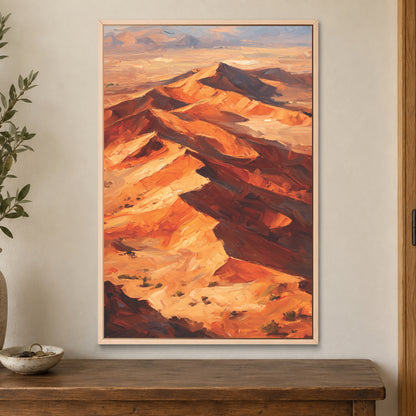 Desert Dunes Aerial Ridge framed canvas in a natural wood floating frame on a cream wall above a wooden sideboard beside a door frame
