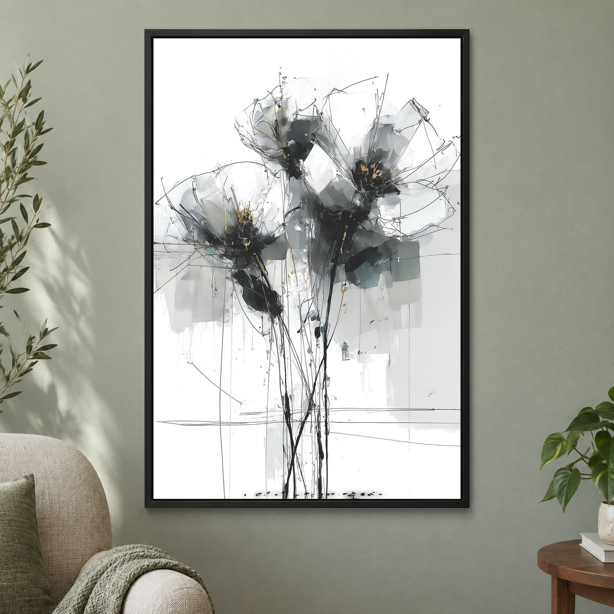 Black and Grey Wildflower Sketch framed canvas in a black floating frame on a sage green wall beside a cream armchair