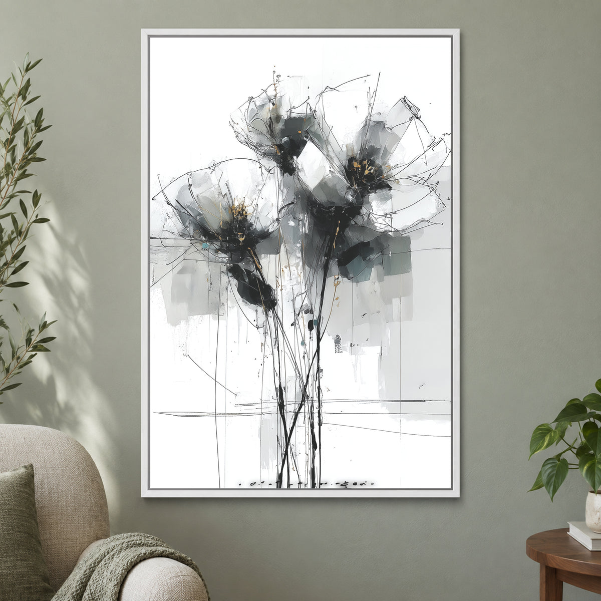Black and Grey Wildflower Sketch framed canvas in a white floating frame on a sage green wall beside a cream armchair