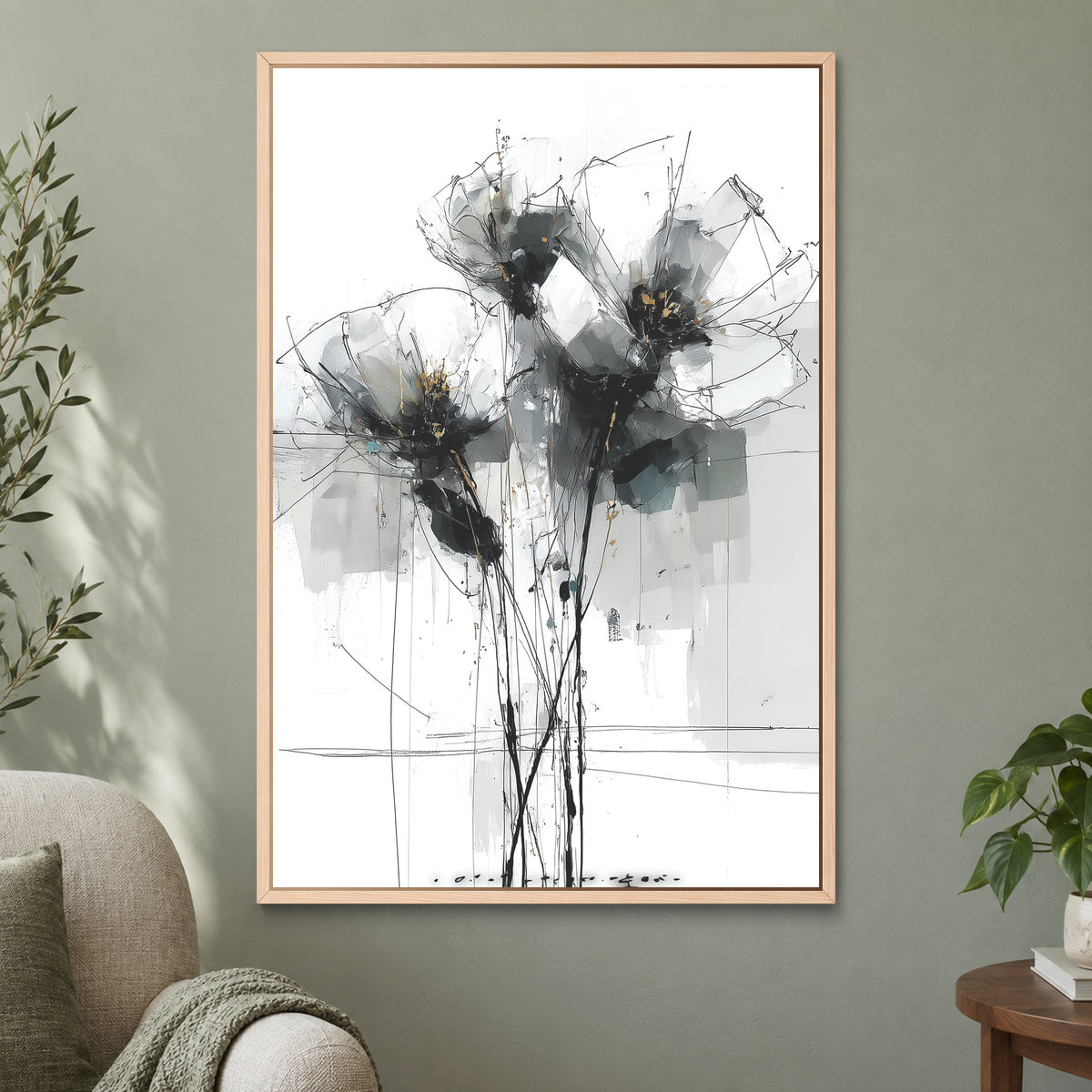 Black and Grey Wildflower Sketch framed canvas in a natural wood floating frame on a sage green wall beside a cream armchair