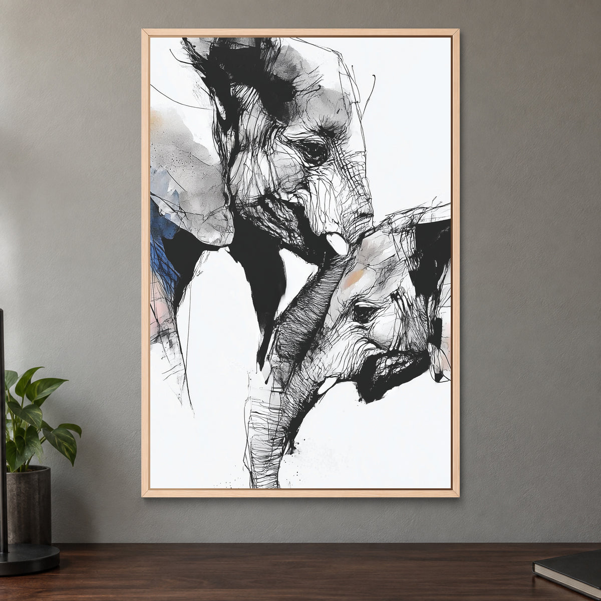 Elephant and Calf Nose to Nose framed canvas in a natural wood floating frame on a taupe wall above a dark walnut sideboard with a potted plant