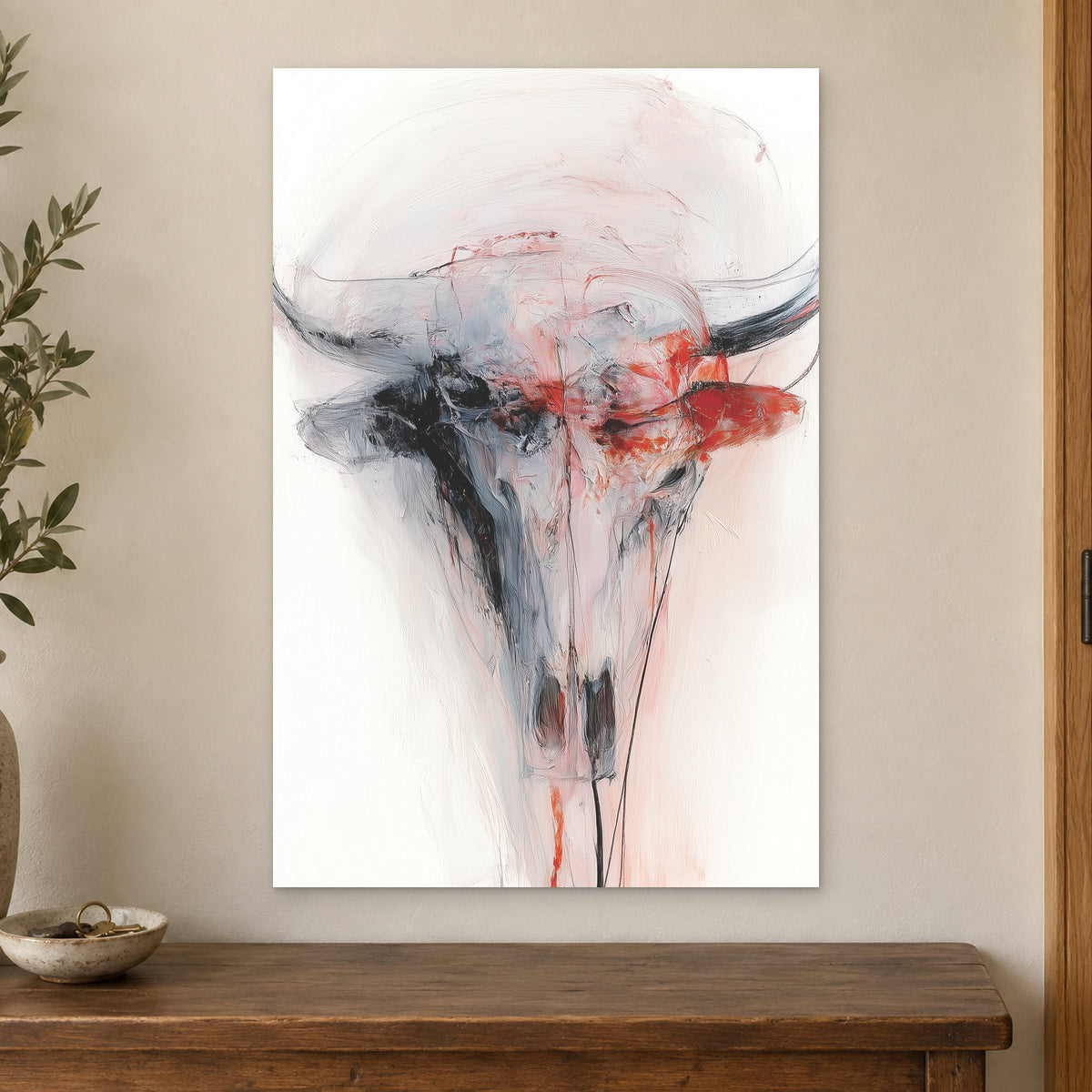Longhorn Skull in Red and White canvas wall art on a cream wall above a wooden sideboard beside a door frame