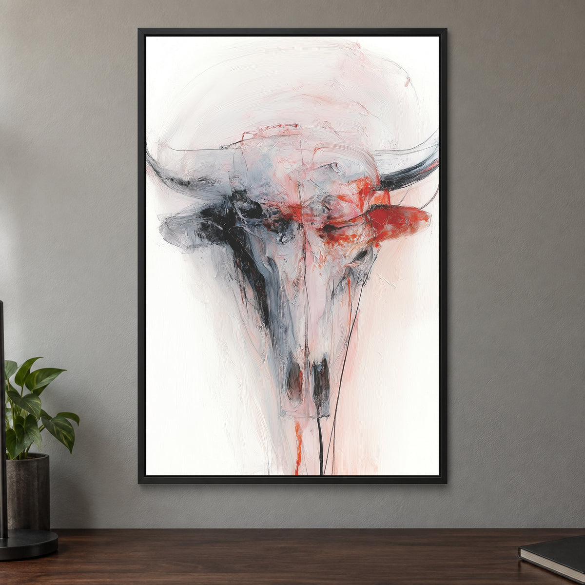 Longhorn Skull in Red and White framed canvas in a black floating frame on a taupe wall above a dark walnut sideboard with a potted plant