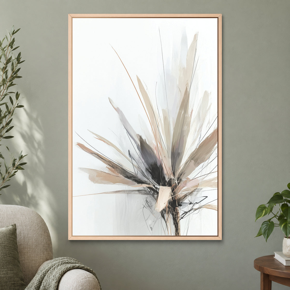 Botanical Sunburst framed canvas in a natural wood floating frame on a sage green wall beside a cream armchair
