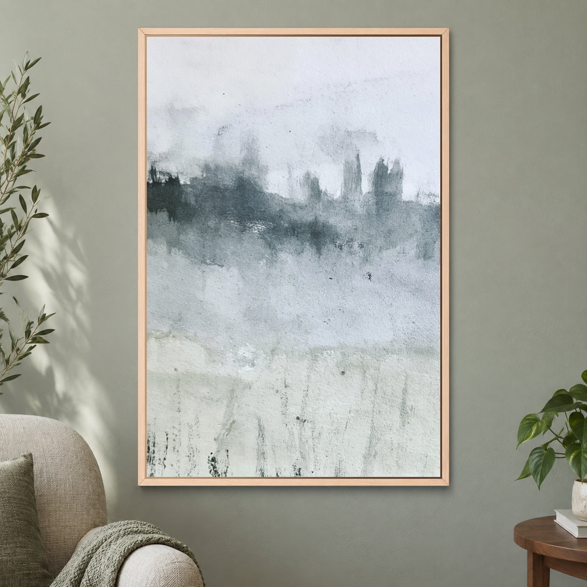 Misty Treeline Minimalist framed canvas in a natural wood floating frame on a sage green wall beside a cream armchair