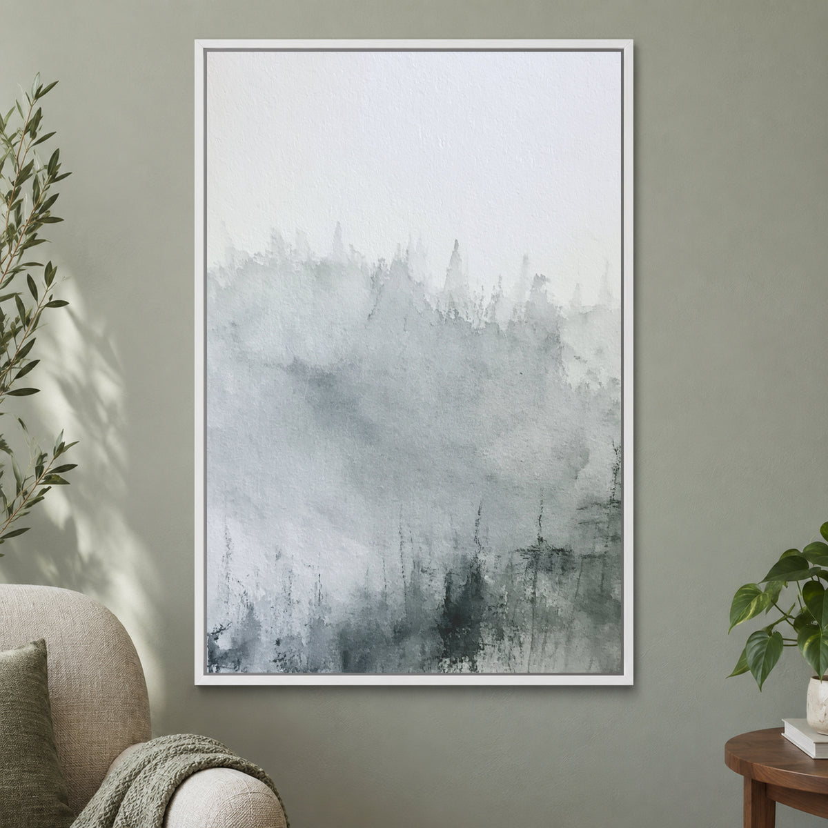 Where the Trees Dissolve framed canvas in a white floating frame on a sage green wall beside a cream armchair