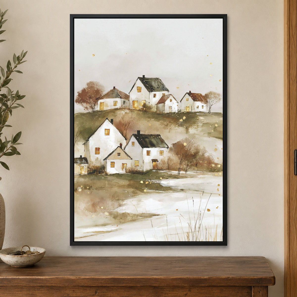 Canadian Prairie Farmhouses Winter framed canvas in a black floating frame on a cream wall above a wooden sideboard beside a door frame