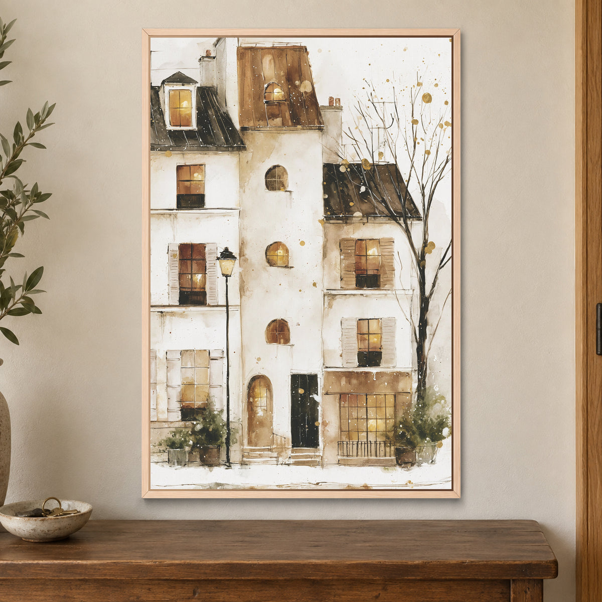 Snowy Paris Windows Watercolour framed canvas in a natural wood floating frame on a cream wall above a wooden sideboard beside a door frame