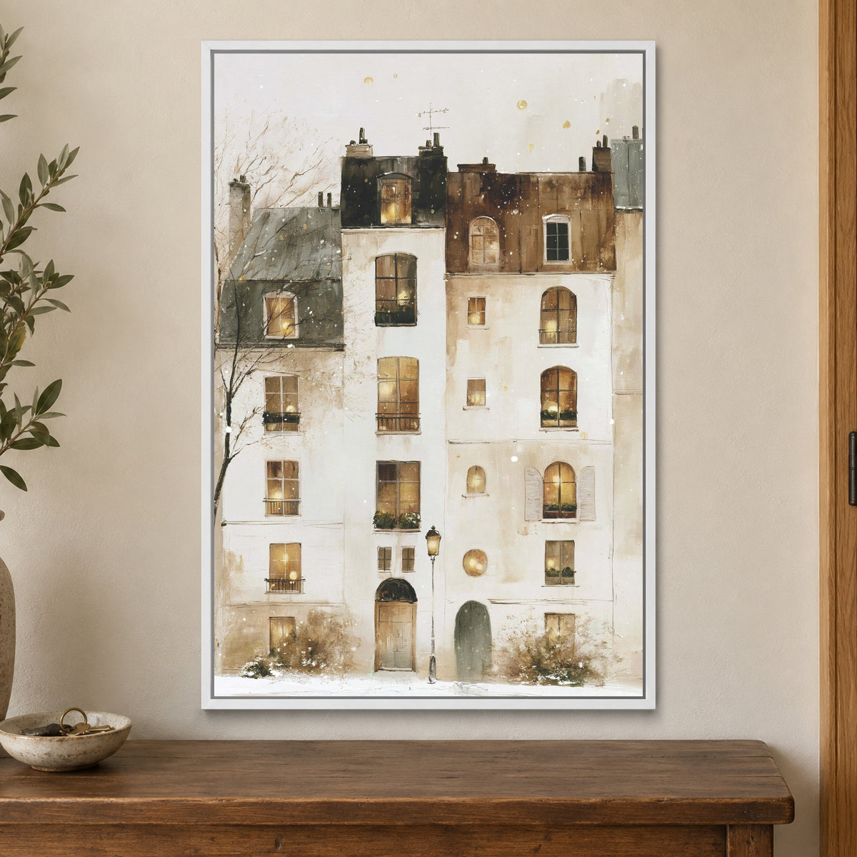 Snowfall in Paris Watercolour framed canvas in a white floating frame on a cream wall above a wooden sideboard beside a door frame