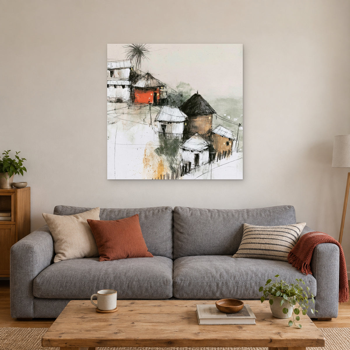 One Red Hut on the Slope canvas wall art above a grey sofa with rust and striped cushions