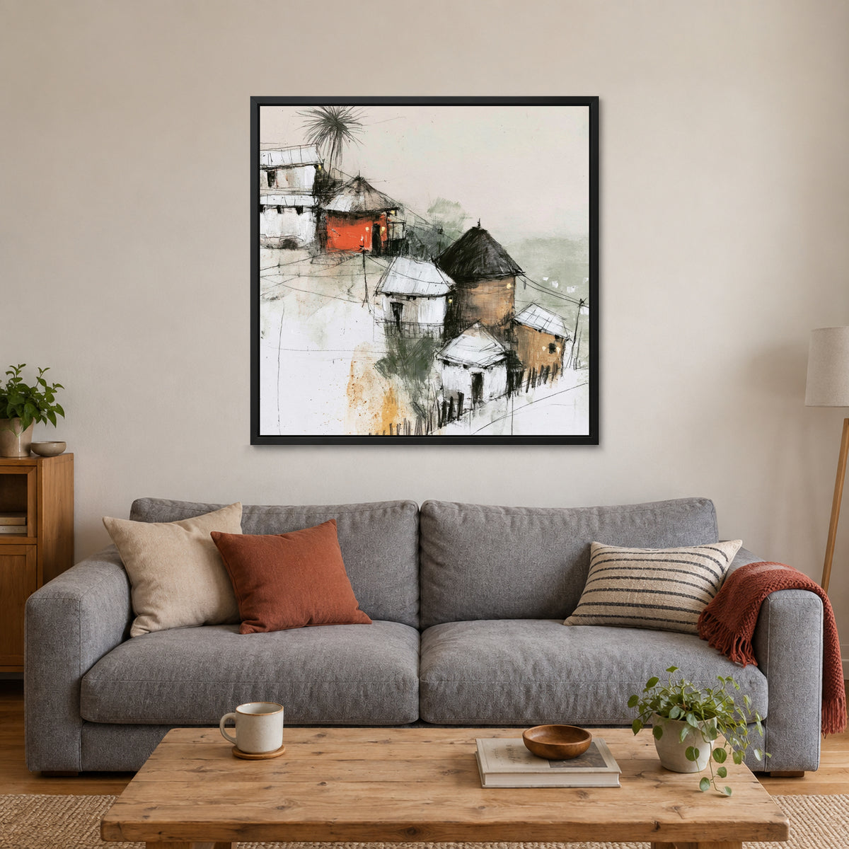 One Red Hut on the Slope framed canvas in a black floating frame above a grey sofa with rust and striped cushions