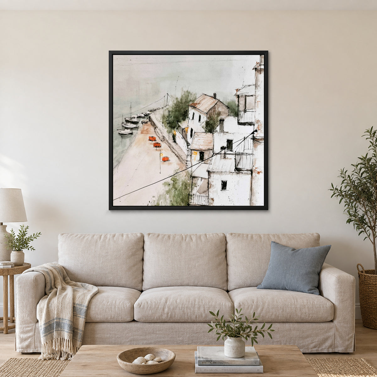 Harbour Houses Above the Quay framed canvas in a black floating frame above a linen sofa with a blue cushion