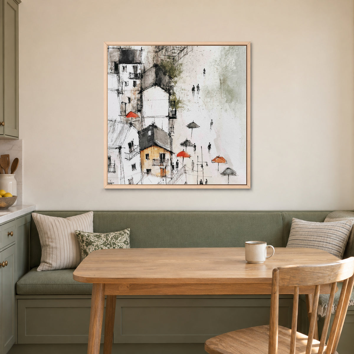 Sicilian Hill Town Pen and Wash framed canvas in a natural wood floating frame above a green banquette and wooden table in a breakfast nook