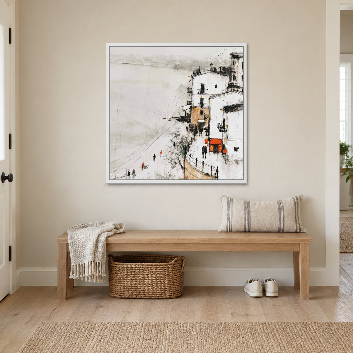 Sicilian Cliff Town Above the Sand framed canvas in a white floating frame above a wooden entryway bench with a woven basket