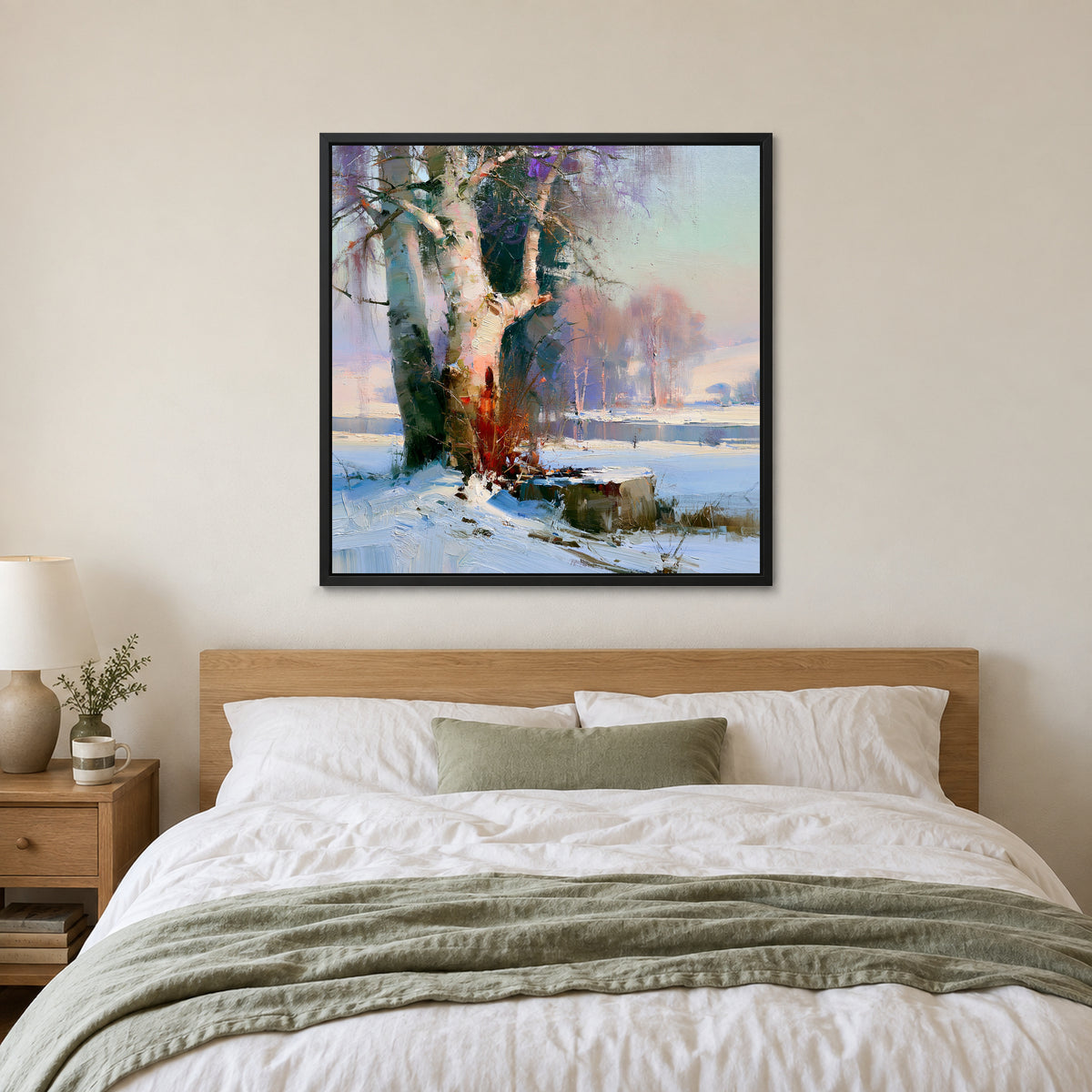 Birches on the Frozen River framed canvas in a black floating frame above a bed with white linens and a sage throw