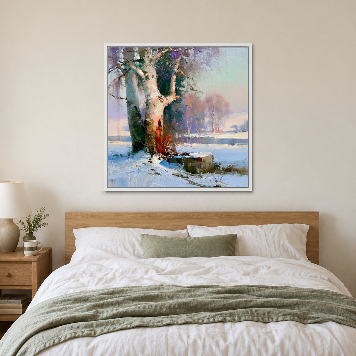 Birches on the Frozen River framed canvas in a white floating frame above a bed with white linens and a sage throw