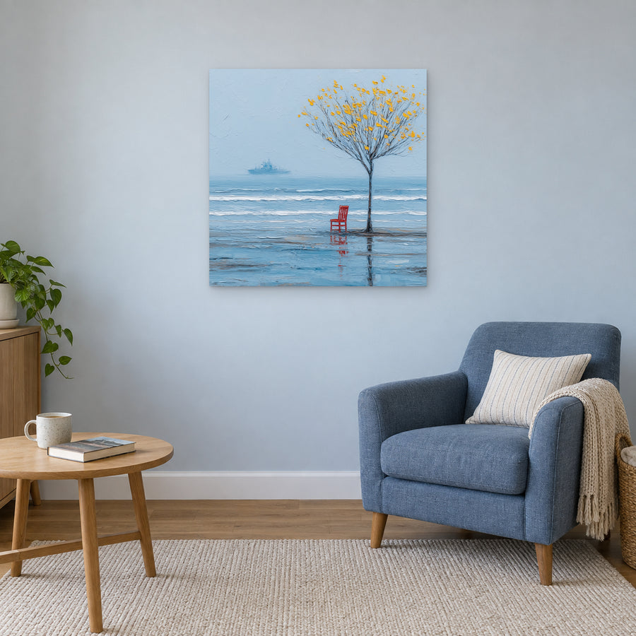 A Red Chair by the Sea canvas wall art above a blue armchair and round wooden side table in a reading corner