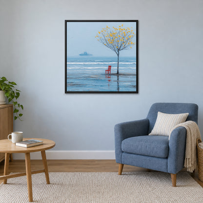A Red Chair by the Sea framed canvas in a black floating frame above a blue armchair and round wooden side table