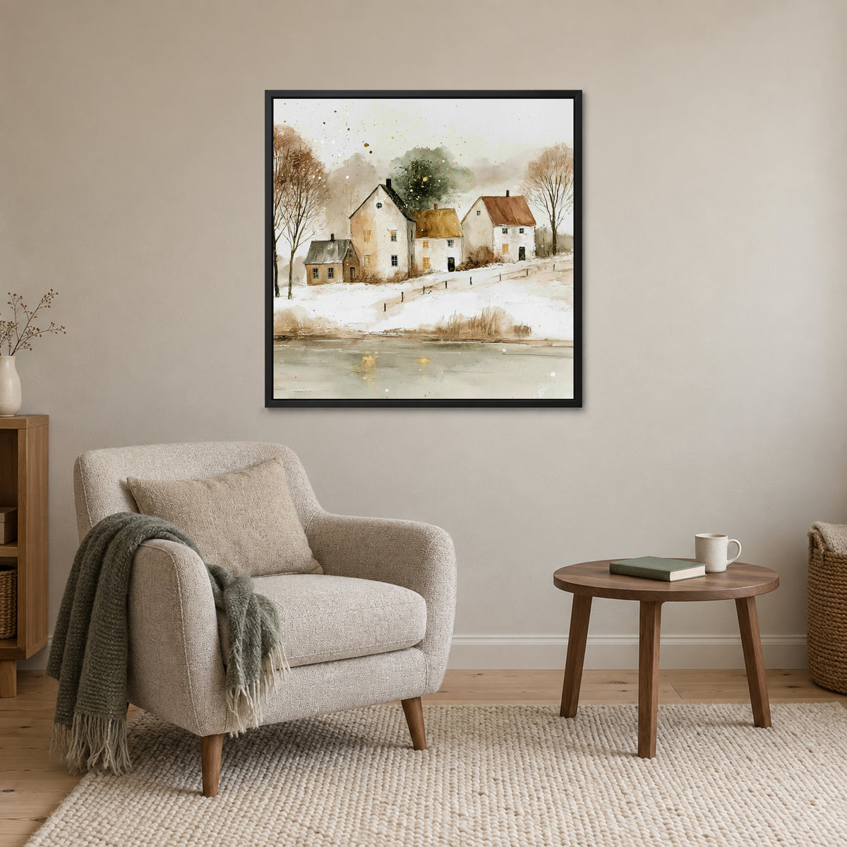 Farmhouses Above the Frozen Pond framed canvas in a black floating frame above a cream armchair and round wooden side table