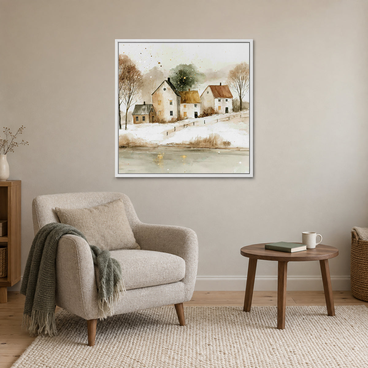 Farmhouses Above the Frozen Pond framed canvas in a white floating frame above a cream armchair and round wooden side table