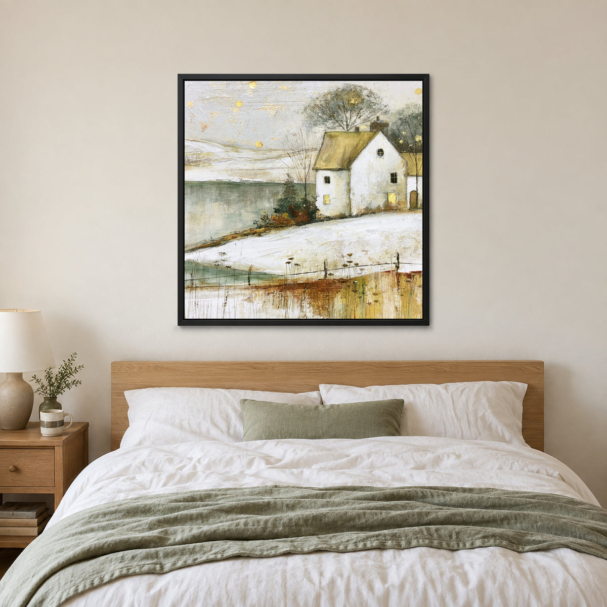 Gold Flecks Over a Frozen Lake framed canvas in a black floating frame above a bed with white linens and a sage throw