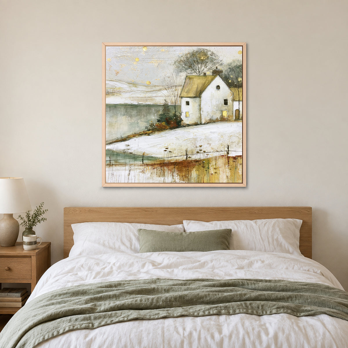 Gold Flecks Over a Frozen Lake framed canvas in a natural wood floating frame above a bed with white linens and a sage throw
