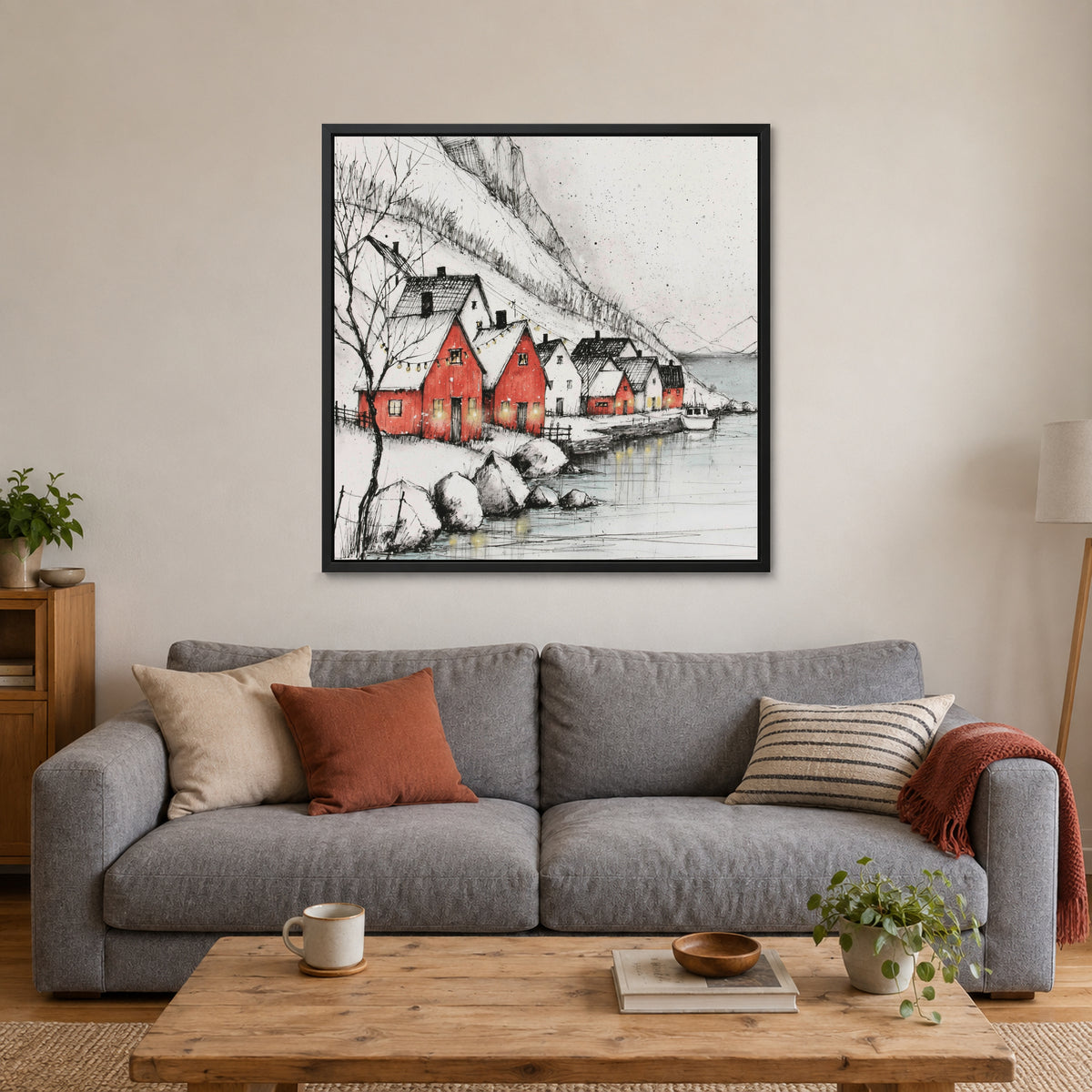 Scandinavian Red Boathouses Winter framed canvas in a black floating frame above a grey sofa with rust and striped cushions